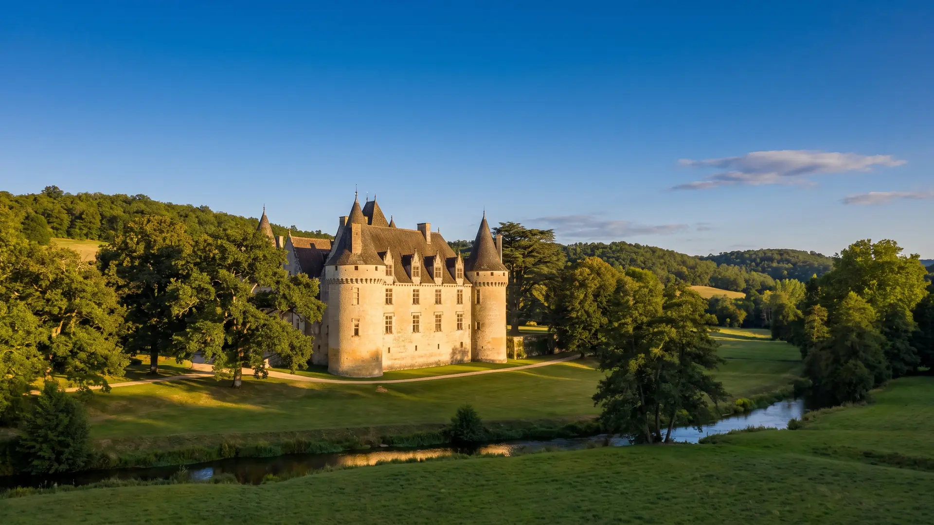Château en pierre dans un parc boisé près du Bugue