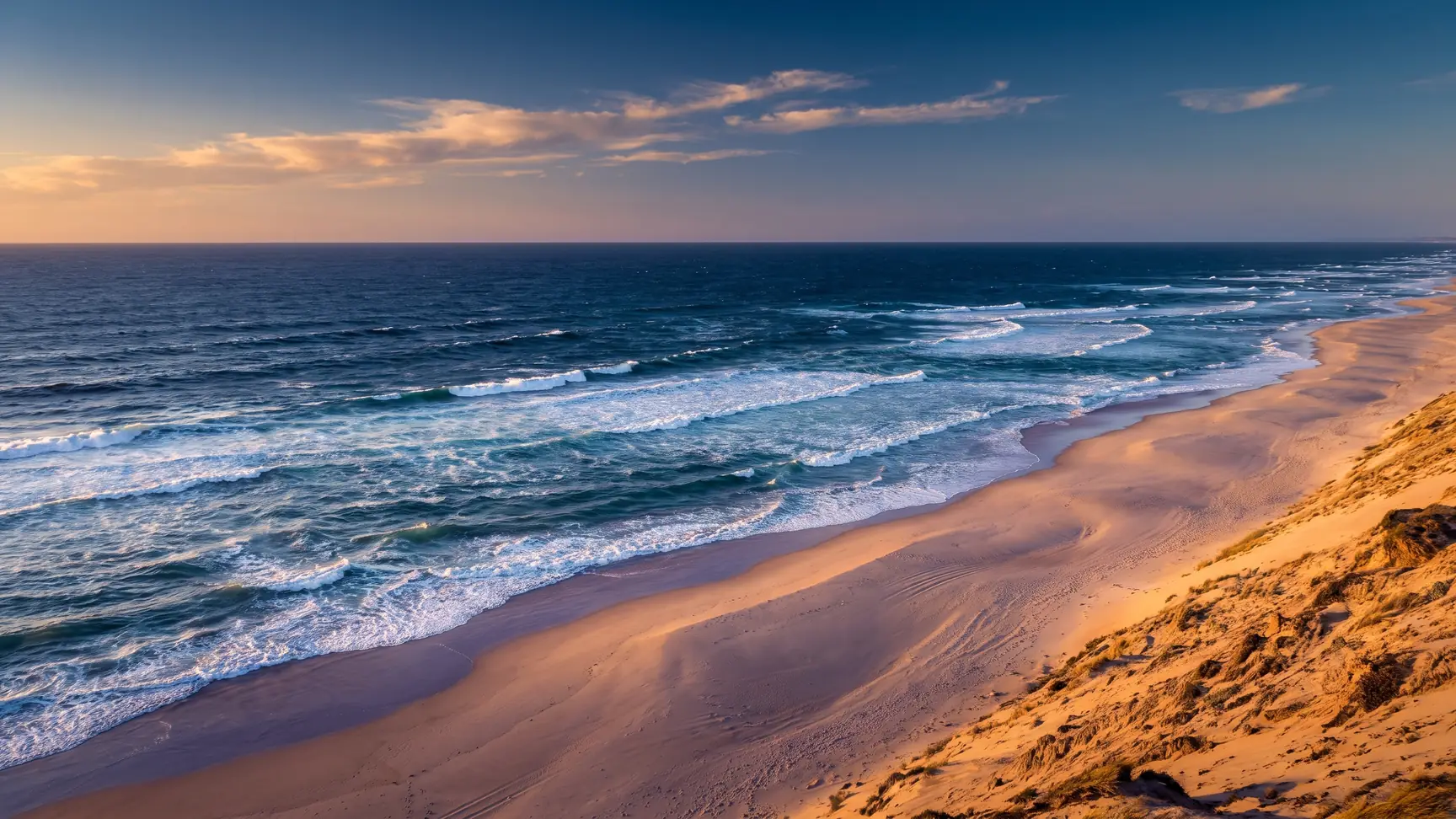L'océan au large de Capbreton, eaux indigo profondes du gouf et houle lisse se réfractant vers la plage