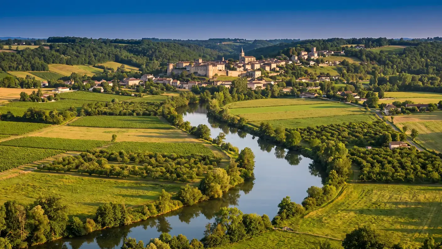 La vallée verte du Dropt dans le Haut-Agenais, champs et vergers en damier, une bastide perchée au loin