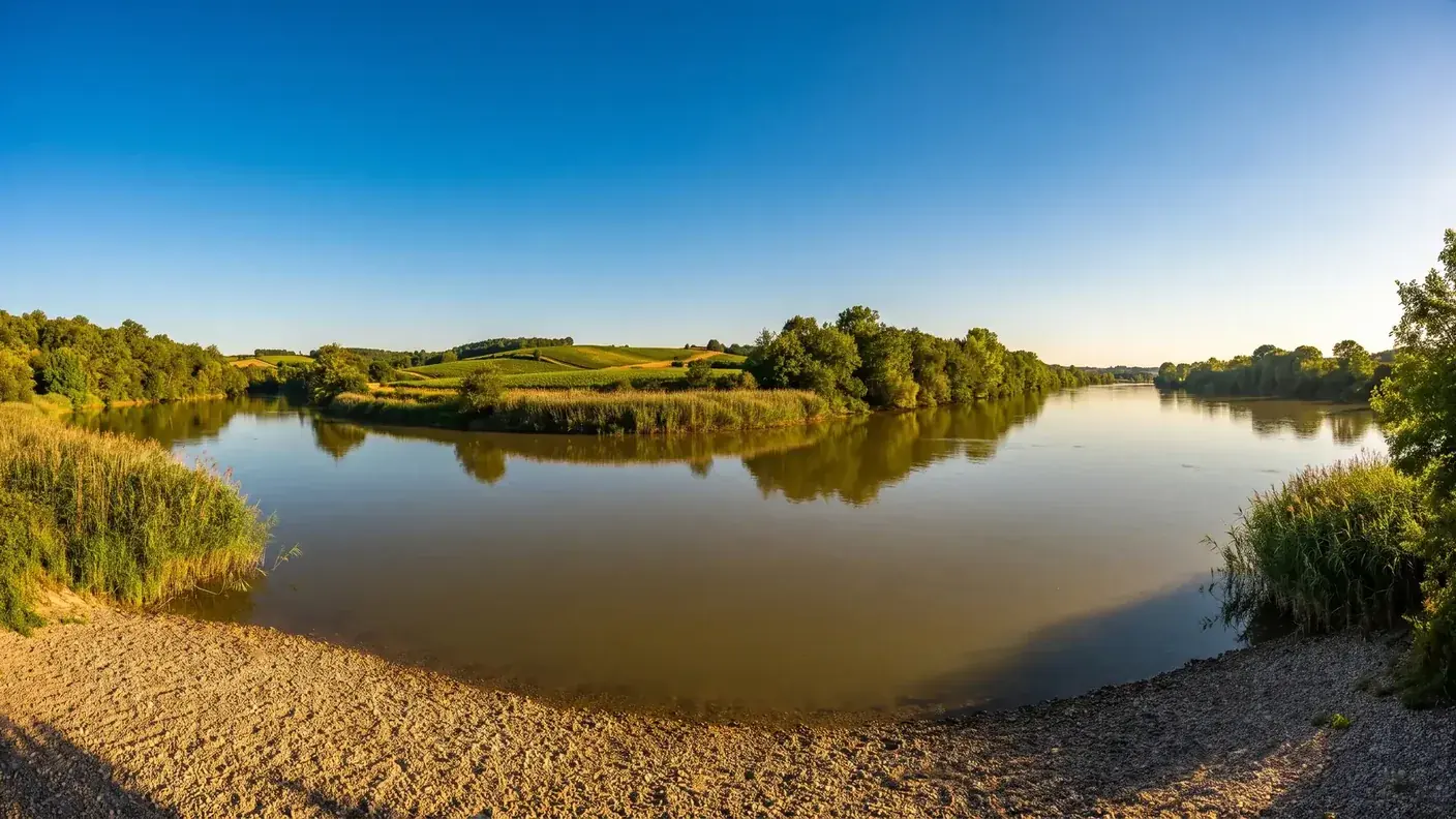La confluence du Dropt et de la Garonne en Gironde à l'heure dorée, deux cours d'eau calmes entre des berges vertes
