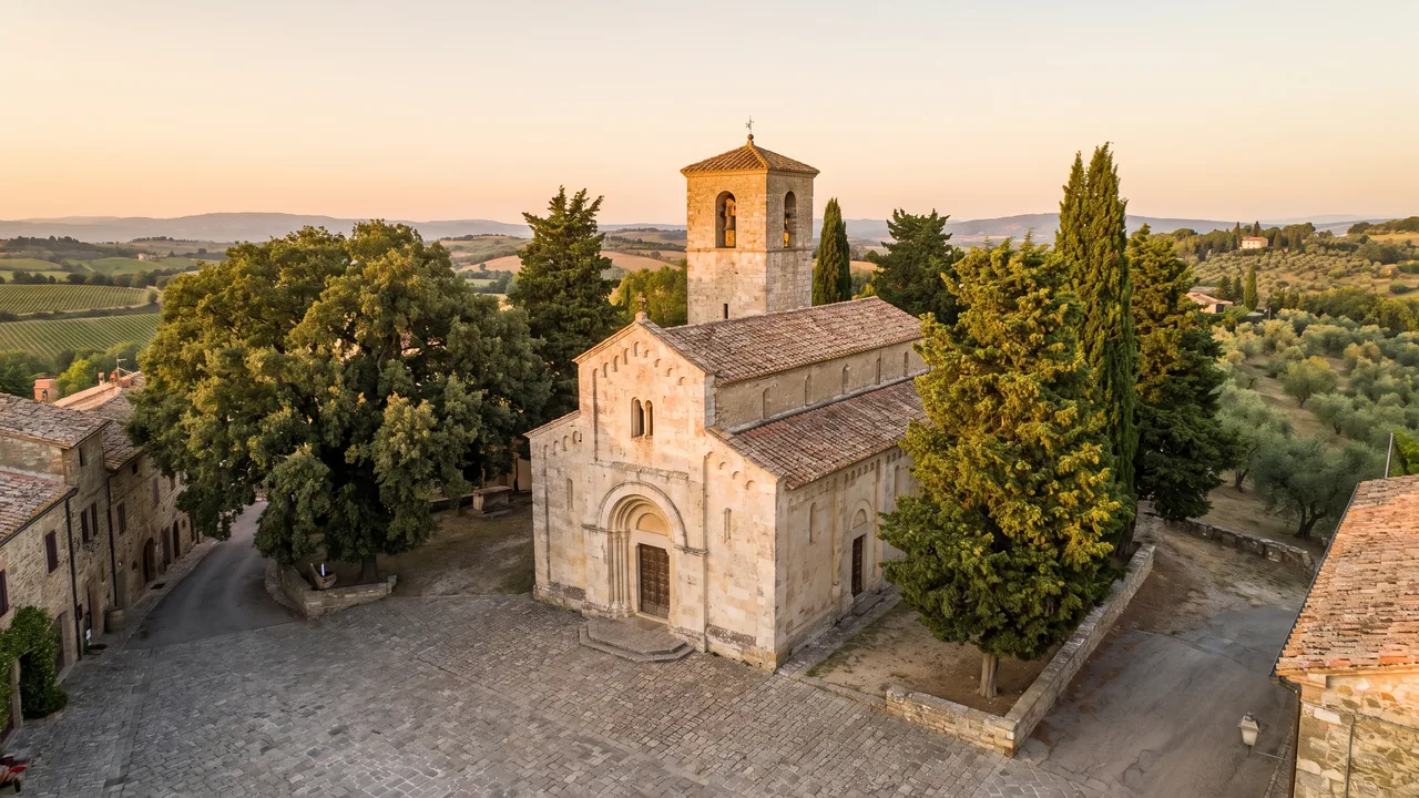 Église romane de pierre claire à Chef-Boutonne, clocher carré et portail en plein cintre au bord d'une place