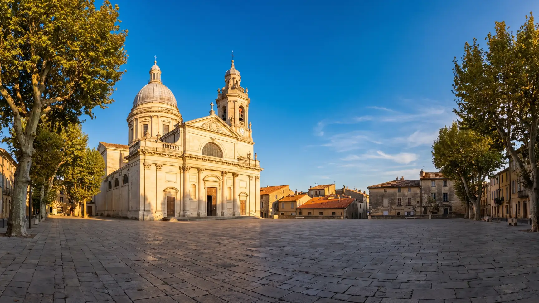Une cathédrale classique à dôme et clocher en pierre claire dominant les toits d'une ville du Sud-Ouest
