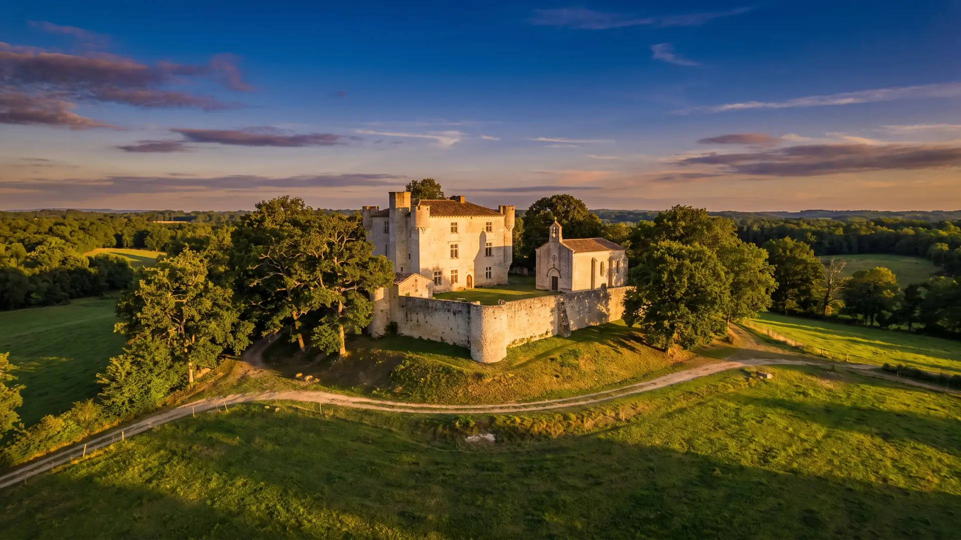 Une petite maison forte médiévale en pierre sur une butte, flanquée d'une chapelle et d'une tour, dans les Landes