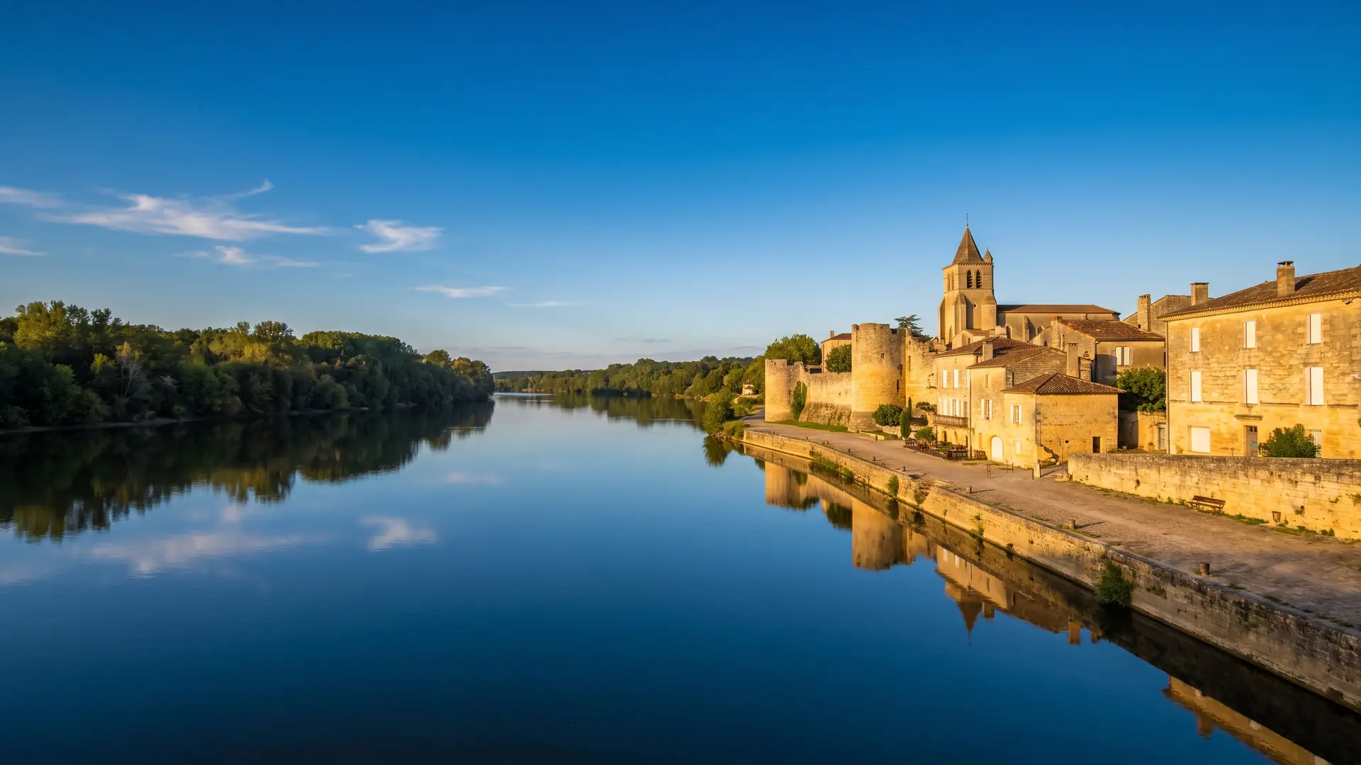 La Garonne longeant les quais de pierre d'une vieille ville aux toits de tuiles, vignes sur l'autre rive