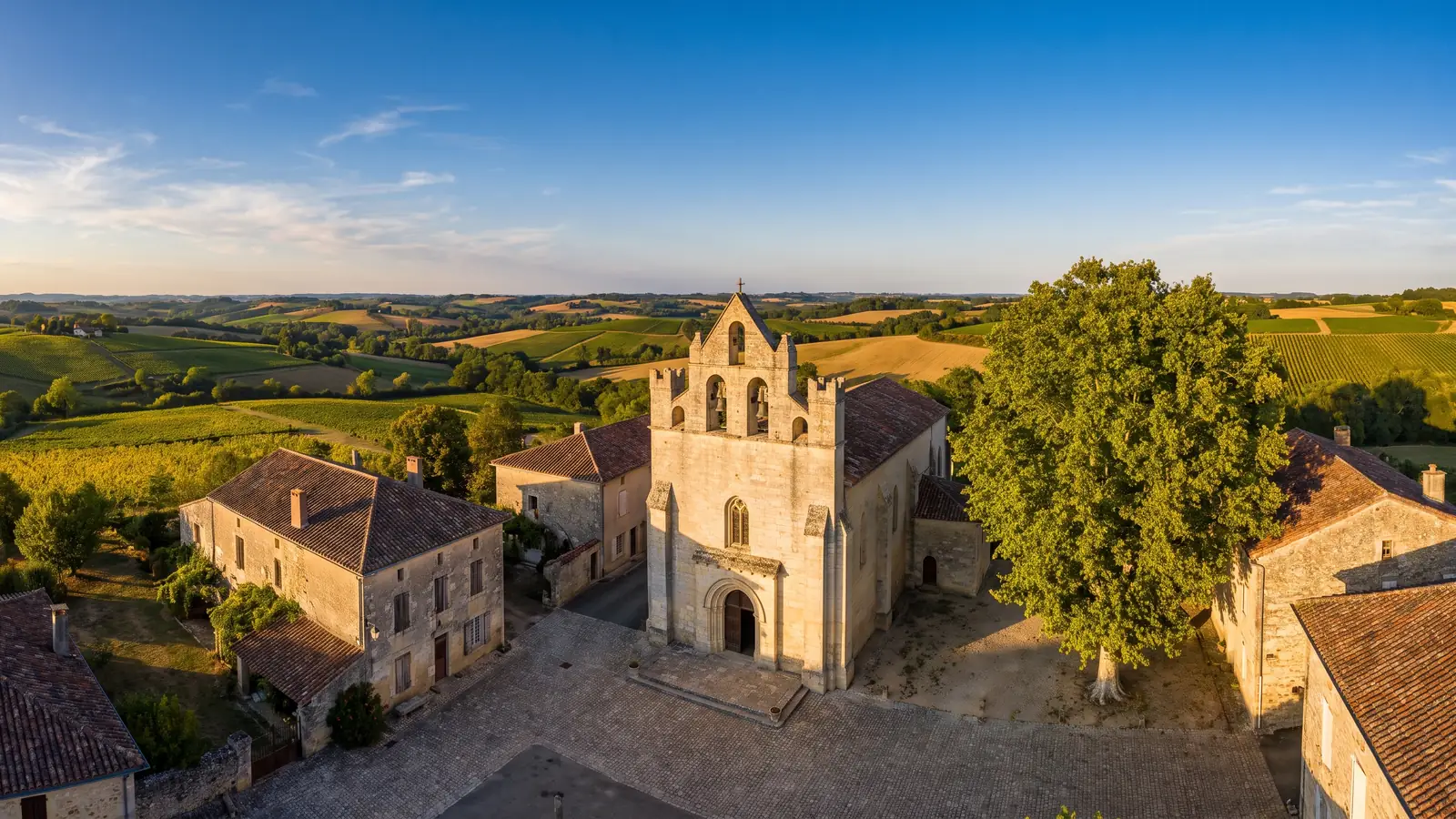 Église rurale en pierre au milieu des coteaux agricoles du Gers