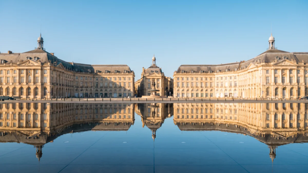 VTC longeant la place de la Bourse et le Miroir d'eau à Bordeaux en journée
