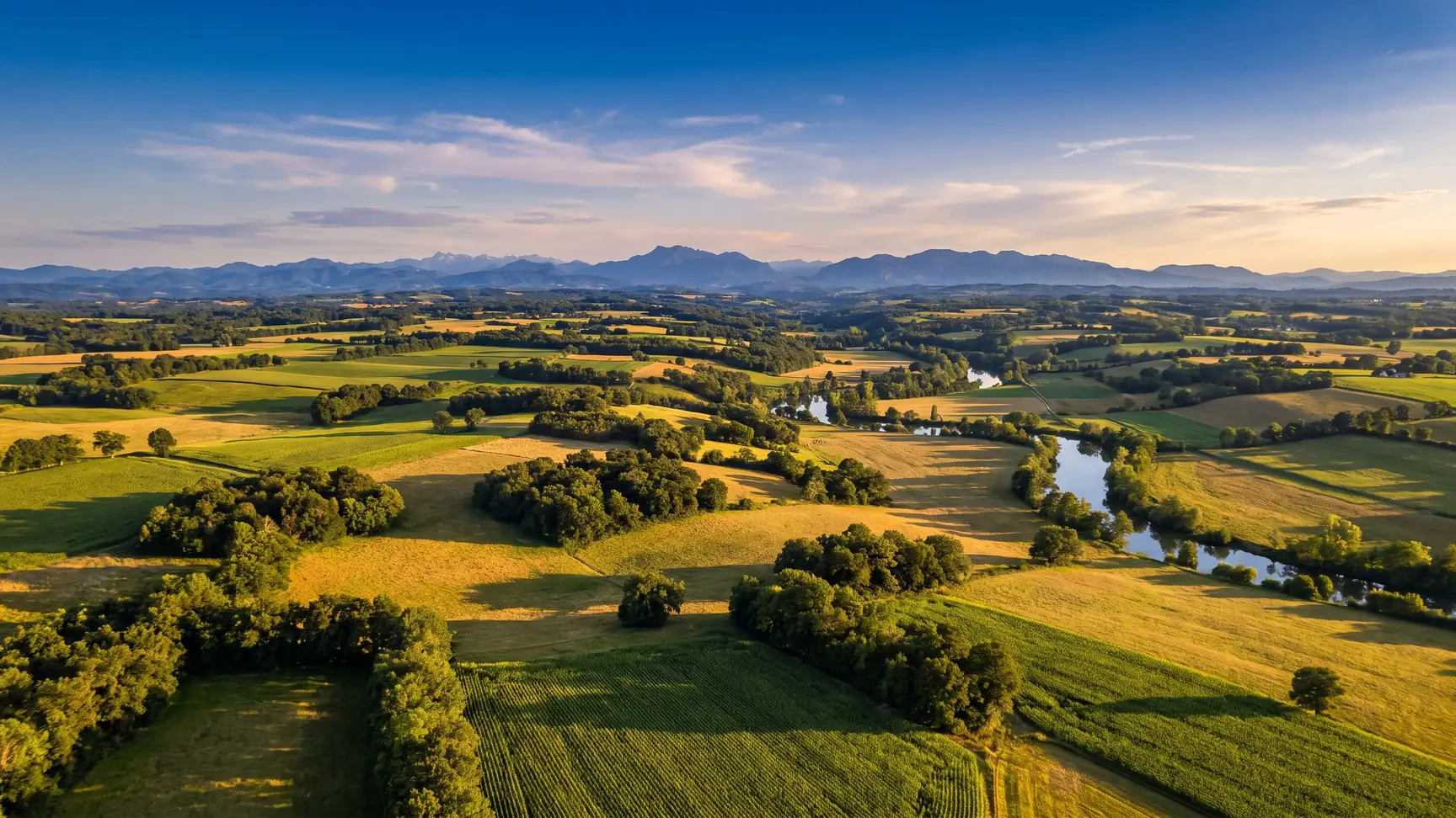 Un vaste panorama du Pays d'Orthe vers la chaîne des Pyrénées à l'horizon, dans les Landes