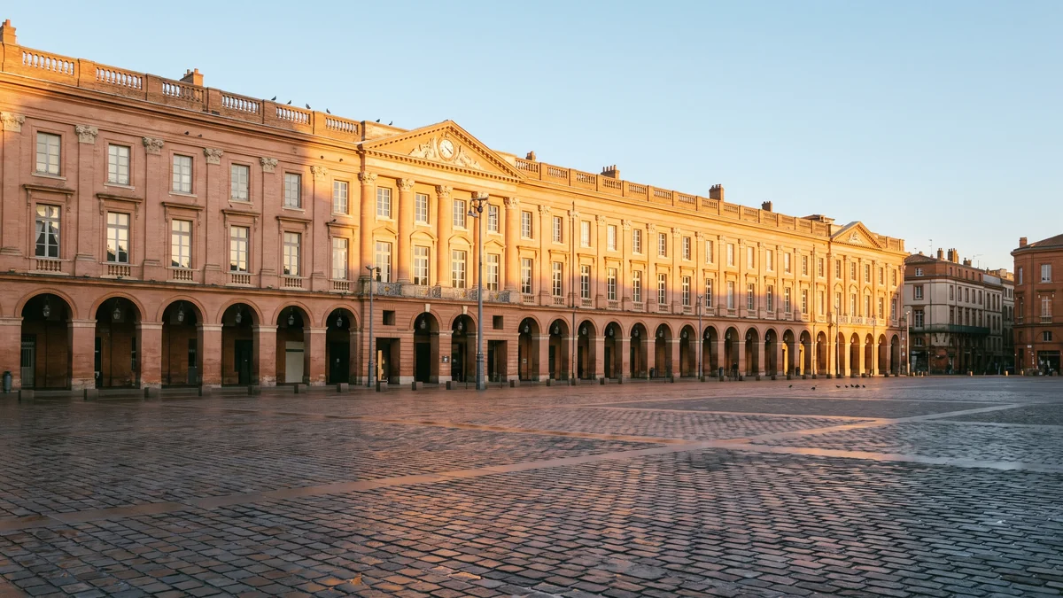 Berline VTC devant les briques roses et la Garonne à Toulouse